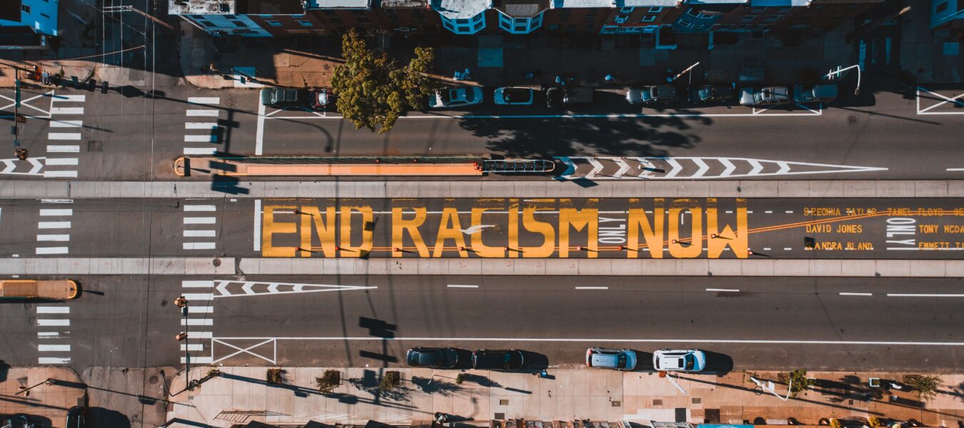 Street aerial view of text reading end racism now