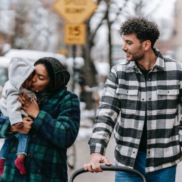 Young family walking outdoors with baby.