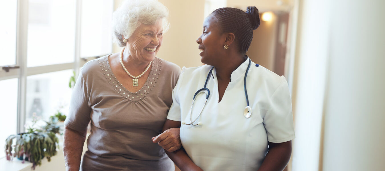 Nurse assisting senior woman at nursing home.