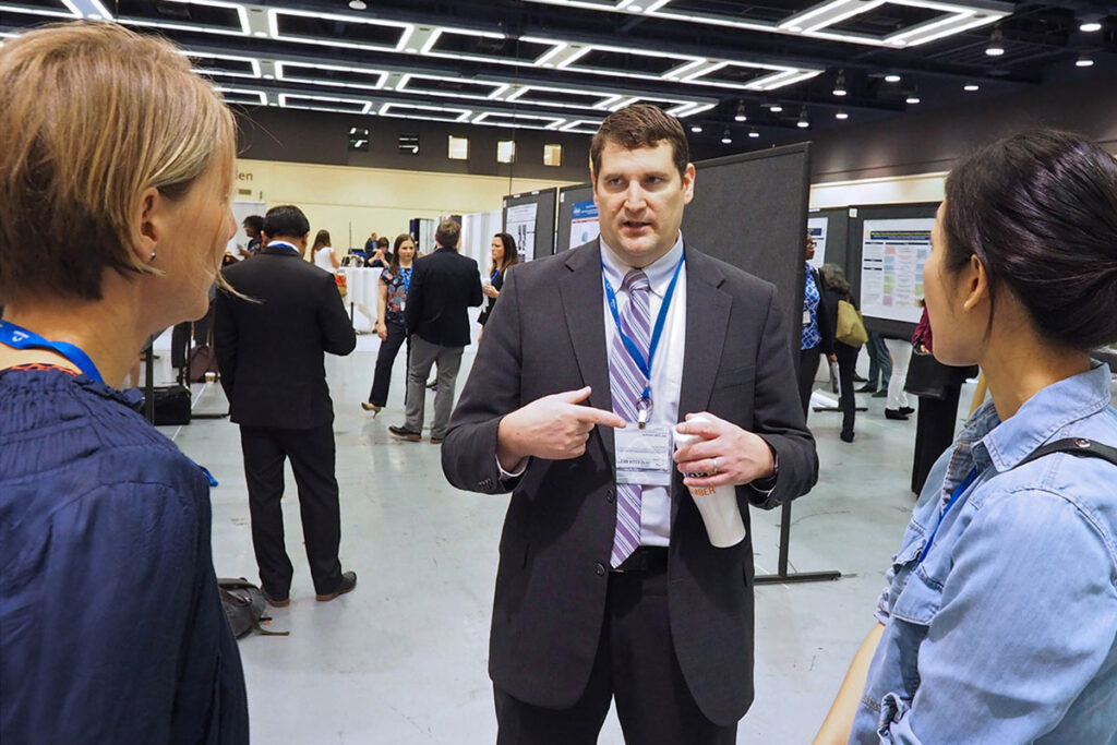 Matthew McHugh, PhD, JD, MPH of the Penn Nursing Center for Health Outcomes and Policy Research talks with Ulrike Muench, PhD, MSN, RN, of the University of San Francisco, and Kyung Mi Kim