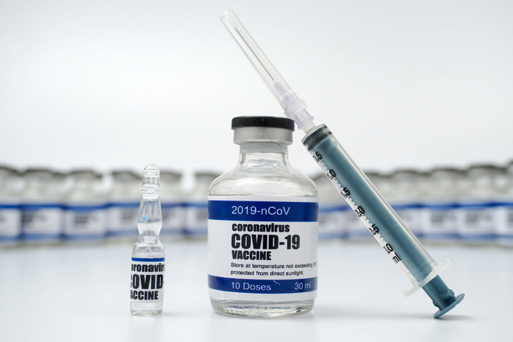 A vial of COVID-19 vaccine and a syringe