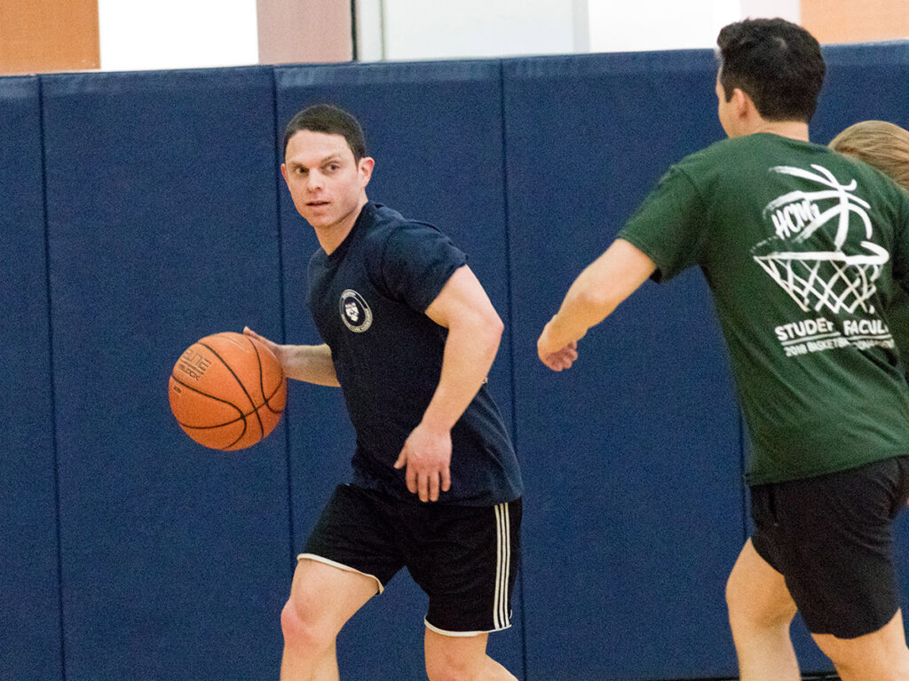 Wharton PhD Student Evan Saltzman, is about to turn the corner on fellow student Stuart Craig in the annual basketball game