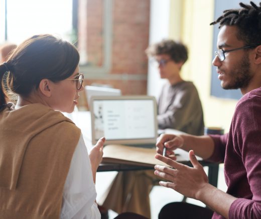 Two people in conversation at a desk.