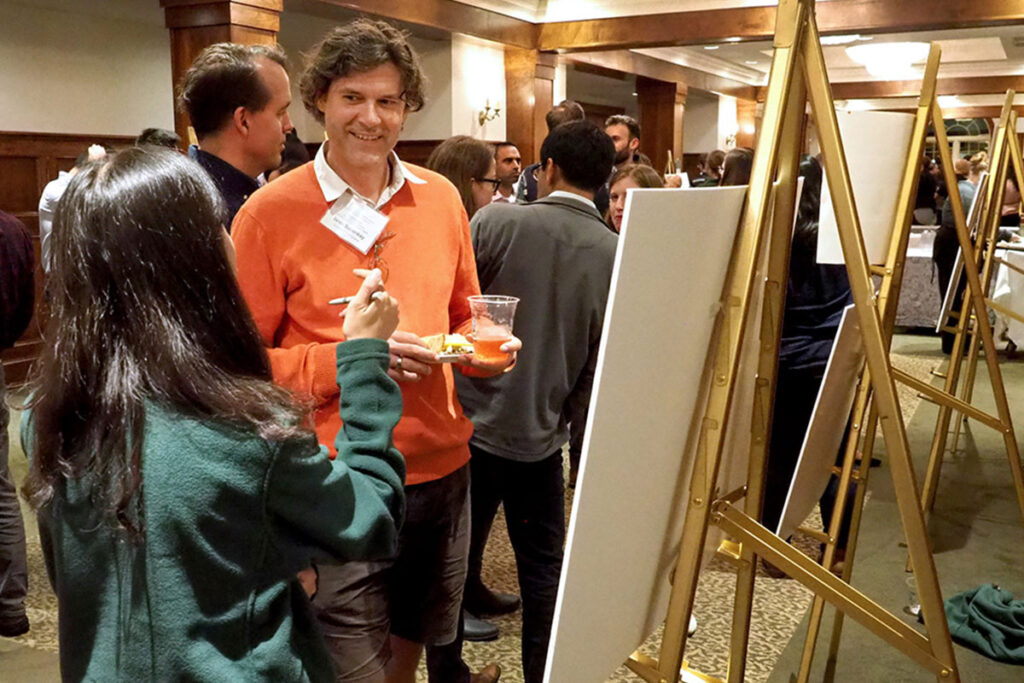 Iwan Barankay, PhD, chats with Yan He, MA, at an academic poster session.