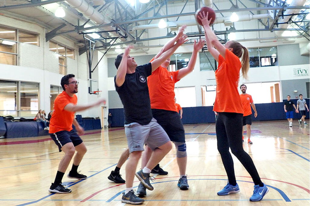 triumphant in her grab for a rebound is student Emma Dean who competed for the ball with PhD student Stuart Craig, professor Daniel Polsky, and Benjamin Ukert