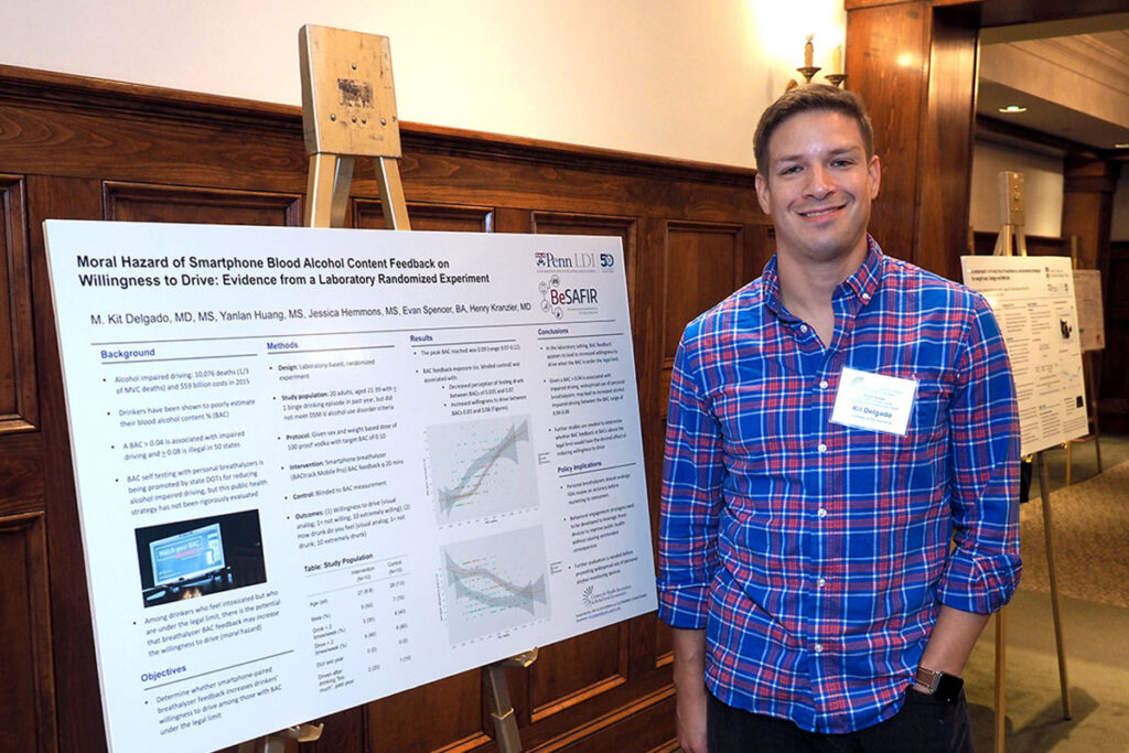 Kit Delgado, MD, MS, with his poster of a study of drivers' response to smartphone blood alcohol levels feedback