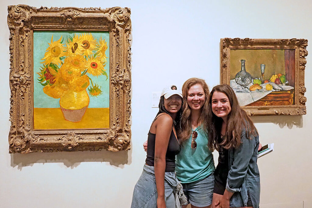 Mara Abera of Penn, Mariah Ramirez of Vanderbilt, and Monica Delgado of the University of Minnesota stand between van Gogh' and Cézanne paintings