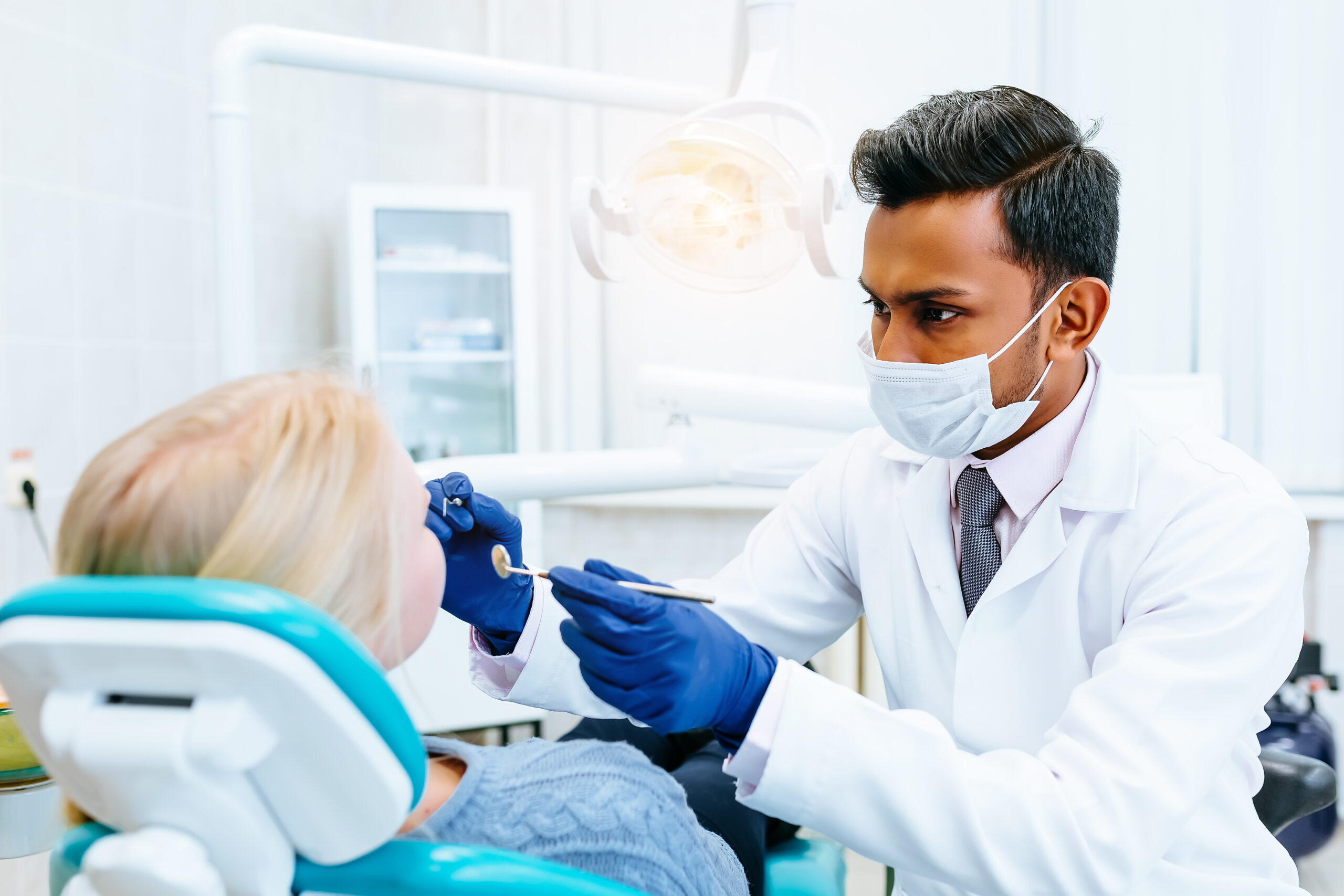 Male dentist Medical treatment to a female patient at the clinic